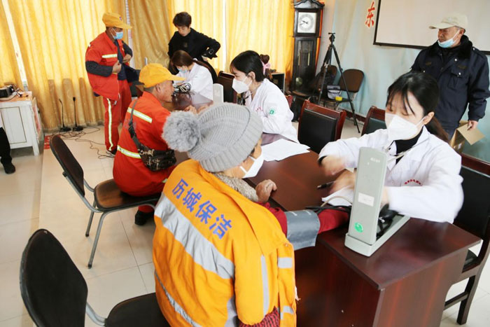 济南齐鲁花园医院医护人员给参会的人员现场进行血压测量，指导大家正确使用健康六件套
