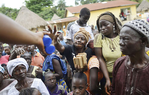 图为7月10日,几内亚,世界卫生组织和红十字会在向民众发放用于对抗埃博拉病毒的药品。