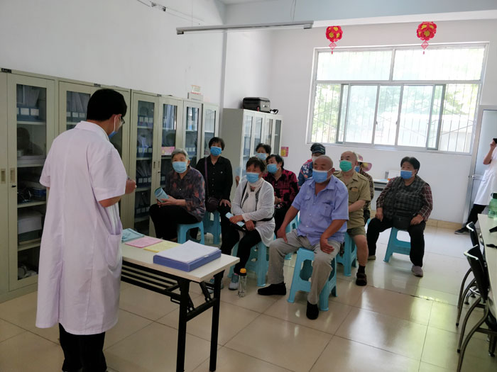 在服务站健康教育管理室,窗户打开保证通风通畅以及居民佩戴口罩的前提下,以健康教育讲座的形式